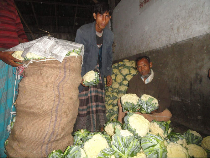Cauliflower sellers at a store of wholesale vegetable market at Goshala in Lalmonirhat town look hapless as the price sees drastic fall amid lack of customers due to transport problem caused by the ongoing countrywide blockade enforced by BNP-led 20-party alliance. PHOTO: STAR