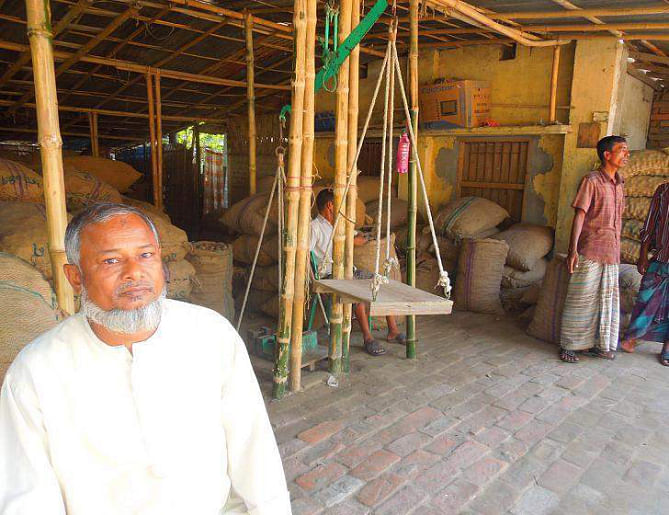 With hardly any customer, a potato seed trader at Mirganj seed market in Nilphamari district passes idle time as farmers are hesitant to buy potato seeds that are mostly without any quality certification of the government's seed department. PHOTO: STAR