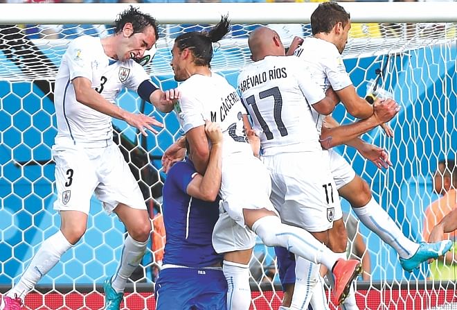 Uruguay captain Diego Godin (L) scores the winning goal against Italy during the World Cup Group D match at the Dunas Arena in Natal yesterday. PHOTO: AFP