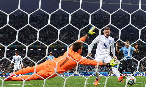 England's forward Wayne Rooney (L) scores against Uruguay's goalkeeper Fernando Muslera (L) during a Group D football match between Uruguay and England at the Corinthians Arena in Sao Paulo during the 2014 FIFA World Cup on June 20, 2014. Photo: Getty Images