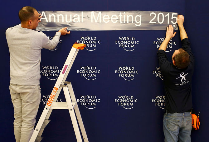 Workers set up logos of the World Economic Forum at the congress centre in the Swiss mountain resort of Davos on Tuesday. Photo: Reuters