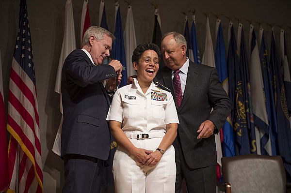 Secretary of the Navy Ray Mabus (L) and Wayne Cowles, husband of Admiral Michelle Howard, put four-star shoulder boards on Howard's service white uniform during her promotion ceremony at the Women in Military Service for America Memorial. Photo: US Navy