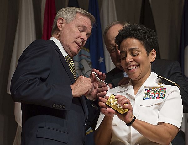 Admiral Michell Howard helps Secretary of the Navy Ray Mabus to put four-star shoulder boards on Howard's service white uniform during her promotion ceremony at the Women in Military Service for America Memorial. Photo: US Navy