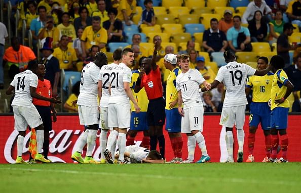 Referee Noumandiez Doue (C) calls a stretcher as Lucas Digne of France lies injured after a challenge by Antonio Valencia (2nd R) of Ecuador during the 2014 FIFA World Cup Brazil Group E match between Ecuador and France at Maracana on June 25, 2014 in Rio de Janeiro, Brazil. Photo: Getty Images