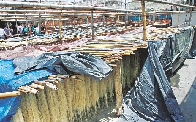 Vermicelli being dried in an unhygienic environment at Mitali Foods, a factory which was sealed off by Dhaka Metropolitan Police yesterday in the capital's Kamrangirchar. DMP also sealed two other factories in the area on the same charge. Photo: Palash Khan