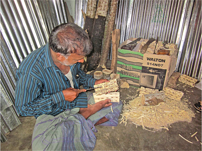 An agar-attar labourer at work exposing the darkened  attar containing parts of the wood.