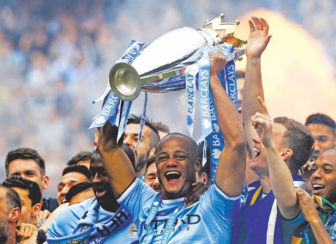 Manchester City's Belgian captain Vincent Kompany hoists the English Premier League trophy after beating West Ham United on the title-deciding final day at the Etihad Stadium yesterday. Photo: Reuters
