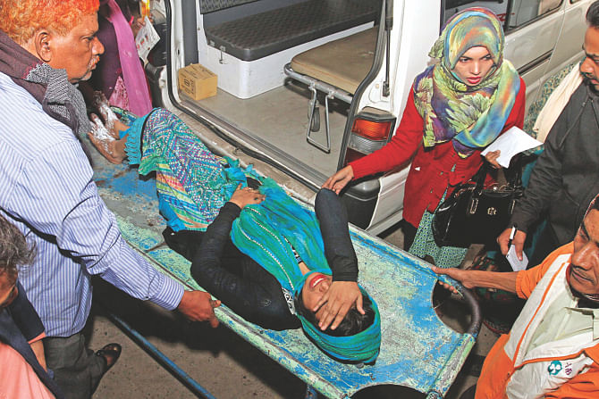 Shathi, a student of Eden College, being taken into the Burn Unit of Dhaka Medical College Hospital yesterday, the 13th day of a blockade being enforced by the BNP-led 20-party alliance. She and two other fellow college mates were injured after alleged pickets hurled a petrol bomb in the bus they were in near the Jatiya Sangsad.  PHOTO: Star, Banglar Chokh
