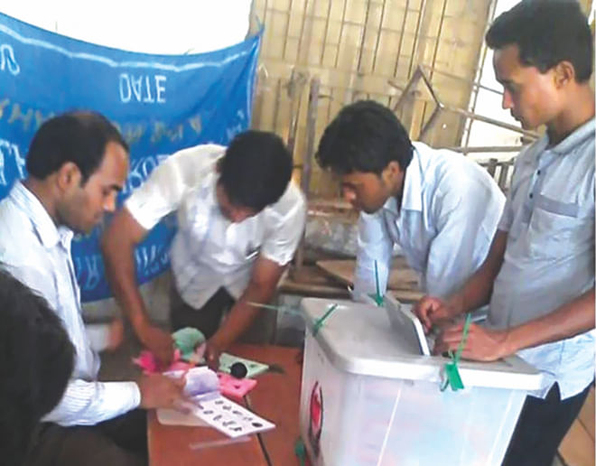 Supporters of Awami League-backed candidates cast fake votes taking ballot papers from Assistant Presiding Office Bikash Chandra Das at Kolakopa Govt Primary School polling centre in Daulatkhan upazila of Bhola at 9:45am Sunday. About 60-70 people actually cast their votes there but the results show 1,026 votes cast and the ruling Awami League-backed candidate got 921 of them. Photo: Md Zakir Hossain