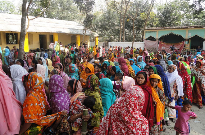 Women voters of Kornai village, who could not cast their votes in the January 5 parliamentary polls due to violence unleashed by BNP and Jamaat-Shibir men, wait in queues in front of Kornai Government Primary School polling centre under Dinajpur Sadar upazila yesterday. Photo: Star