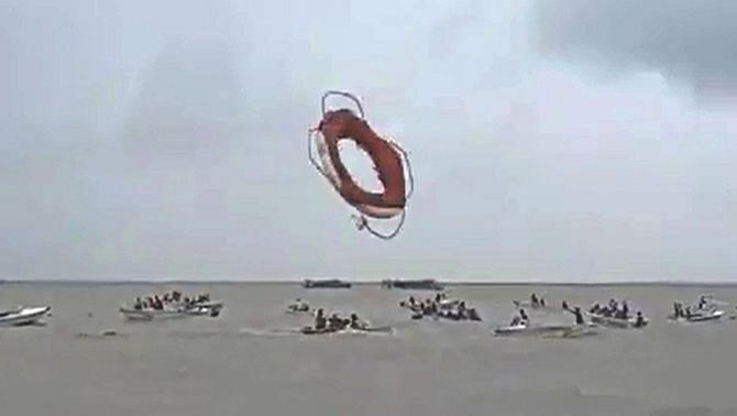 This image taken from a video captured by an eyewitness shows a lifebuoy of a passing ferry being thrown into the Padma where people on speedboats were trying to pull passengers of Pinak-6 out of the water moments after it sank.  Photo: Video Grab