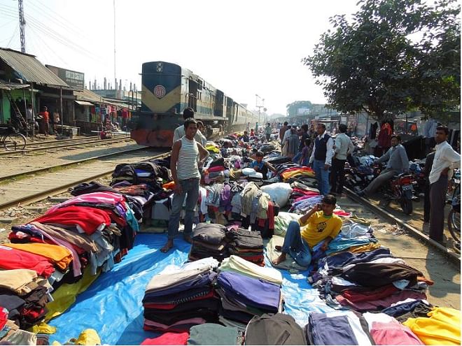 Ignoring the risk of fatal accident anytime, dozens of second hand warm clothes sellers have set up makeshift shops just beside the rail lines at Saidpur station in Nilphamari district, although there is ban on setting up any sales centre within 20 metres from the tracks. PHOTO: STAR
