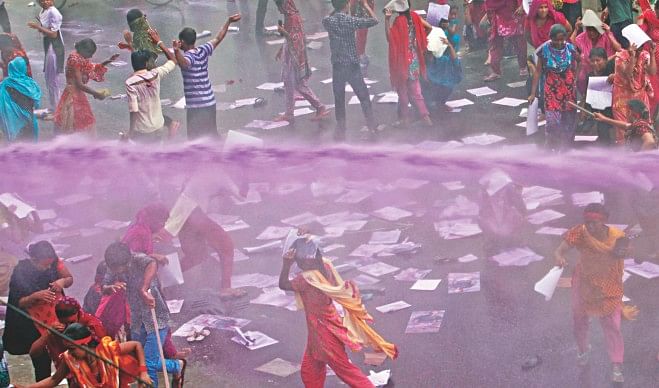 Police use a water cannon to disperse garment workers of five factories of Tuba Group, the parent company of Tazreen Fashions Ltd, in front of Hossain Market of the capital's Badda yesterday. The workers blocked Kuril Bishwa Road for half an hour, demanding arrears of two months and the salaries of the first 15 days of the current month in addition to the Eid bonus. Police also charged batons, leaving at least 10 demonstrators injured. Photos: Courtesy