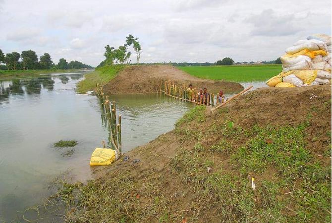 Water Development Board on Thursday started work to repair the breached portion of Nilphamari-Dinajpur branch canal under Teesta Irrigation Project at Dangapara village in Nilphamari Sadar upazila. But aman paddy of around 70 acres of land, flooded due to the onrush of water through the breach, is likely to be fully damaged as the work progresses at a snail's pace. PHOTO: STAR