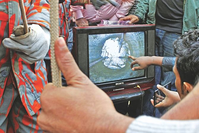 People looking at a TV screen to view the images being fed by the camera. Photo: Collected\Rashed Shumon