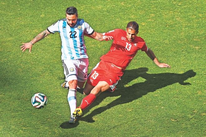 Argentina's Ezequiel Lavezzi (L) and Switzerland's Ricardo Rodriguez fight for possession during their World Cup round of 16 game at the Arena de Sao Paulo on Tuesday. The match was locked at 0-0 at half time. PHOTO: GETTY IMAGES