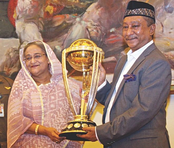 Prime Minister Sheikh Hasina (L) receives the 2015 ICC World Cup trophy from BCB president Nazmul Hassan Papon at the Gono Bhaban yesterday. The coveted silverware, which is making its rounds through all the participating nations of the mega event, was put on display at the Bashundhara City Complex yesterday for thousands of excited spectators. PHOTO: STAR 