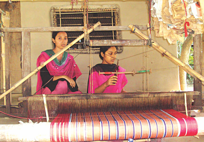 Twins Sharmin and Shahana weaving traditional towels at Aruashakua of Kaliganj in Jhenidah. They support their family and pay for their education doing this. Photo: Star
