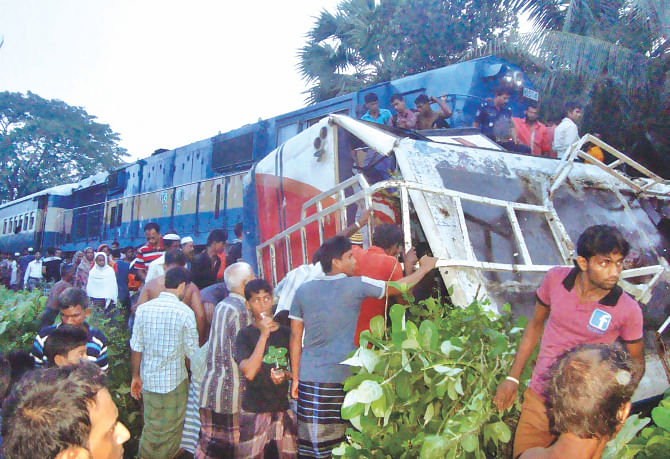 The wrecked bus on its side after Simanta Express from Saidpur rammed it at Barobazar level crossing, about 12 miles from Jessore, and dragged it half a kilometre, killing 11 people returning from a wedding early yesterday.  Photo: Azibor Rahman