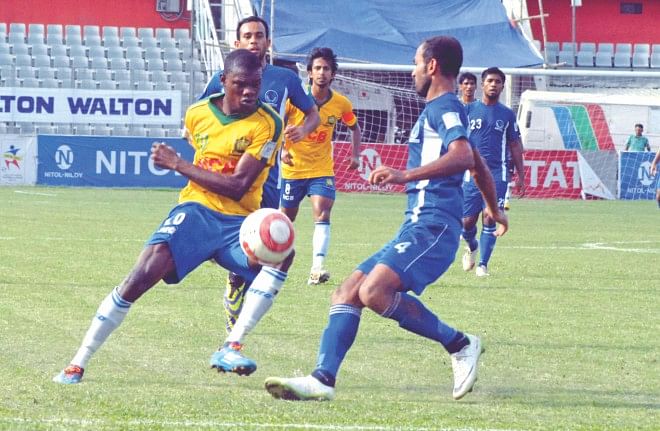 Sheikh Jamal's Haitian striker Wedson Anselme (L), who scored twice to take his tally to 26 goals, tries to outwit Sheikh Russel defender Rezaul Karim in their Bangladesh Premier League match at the Bangabandhu National Stadium yesterday.  PHOTO: STAR