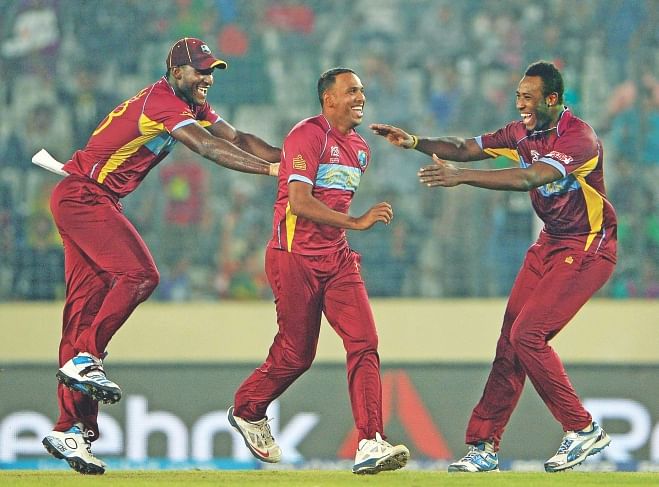 West Indies bowler Samuel Badree, centre, celebrates with captain Darren Sammy, left, and Andre Russell after taking the wicket of Pakistan batsman Shoaib Malik during the ICC World Twenty20 tournament cricket match between Pakistan and West Indies at Sher-e-Bangla National Cricket Stadium in Dhaka yesterday.   Photo: AFP