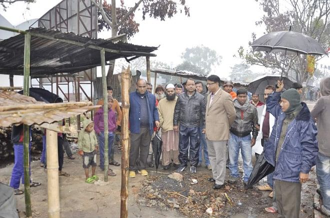 Jatiya Sangsad Whip and Awami League leader Iqbalur Rahim yesterday visits Okrabari bazaar where shops belonging to Hindus were torched allegedly by BNP and Jamaat activists after January 5 JS polls. PHOTO: STAR