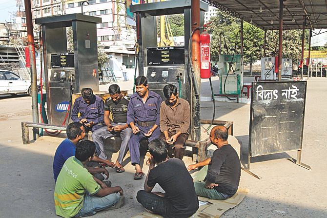Helps at a CNG filling station in Moghbazar, sit around and chat as the station closed having no power. Photo: Rashed Shumon/Palash Khan