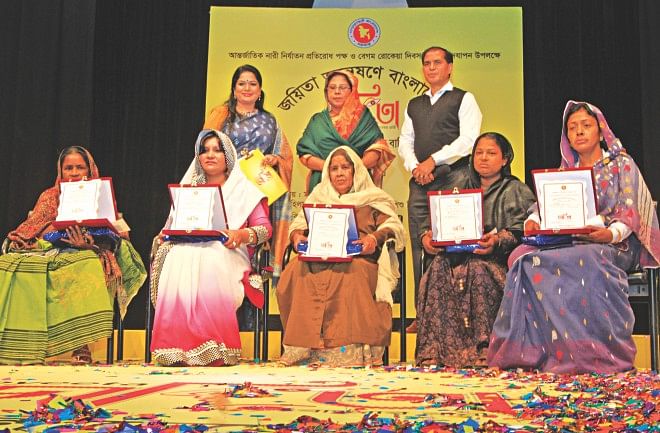 (Sitting from left) Rabeya Khatun, Shahnewaz Dilruba Khan, Begum Suraiya, Selina Aktar Shilpi and Sufia Begum Rozi with awards they received in recognition of their feats in fighting adversities and contributing to society. The award was presented by the Department of Women Affairs in association with Dhaka Deputy Commissioner's Office at the capital's Bangladesh Shilpakala Academy, marking International Day for the Elimination of Violence against Women, and Begum Rokeya Dibash 2013. Standing from left are the programme's moderator Munira Yusuf Memi, State Minister for Women and Children Affairs Meher Afroz Chumki, and Dhaka Divisional Commissioner Zillar Rahman. Photo: Star