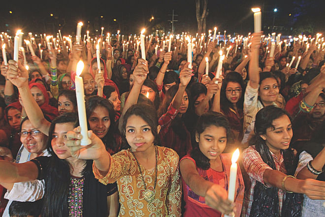 INSPIRING CHANGE: In the first minute of International Women's Day today, people hold up lighted candles and vow to fight for change at the Central Shaheed Minar in Dhaka.  Photo: palash khan