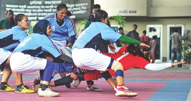 Dhaka players pounce on a Narail raider during the final of the Inter-District Women's Kabaddi Championship at the Volleyball Stadium in Paltan yesterday. PHOTO: STAR
