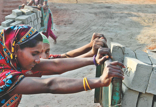 Female labourers doing the heavy lifting just like their male colleagues at a brick kiln near Kamrangirchar in the capital yesterday. Today is International Women's Day. Photo: Anisur Rahman