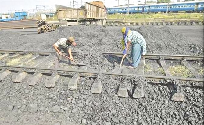Workers clear a track in a railway coal yard on the outskirts of Ahmedabad, India. Photo: REUTERS/File 