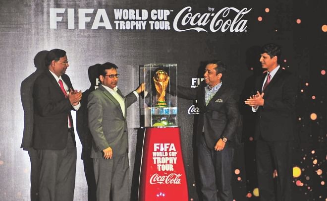 BFF's senior vice-president Abdus Salam Murshedy (2nd from L) and Coca-Cola officials admire the FIFA World Cup trophy during its unveiling ceremony at the Radisson Hotel in city yesterday. PHOTO: FIROZ AHMED