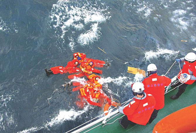 Japanese Coast Guard personnel fish crew members of Ming Guang out of the chilly waters between Honshu and Hokkaido islands on Friday. The crew members abandoned ship after it started listing and finally sank. Photo: AFP