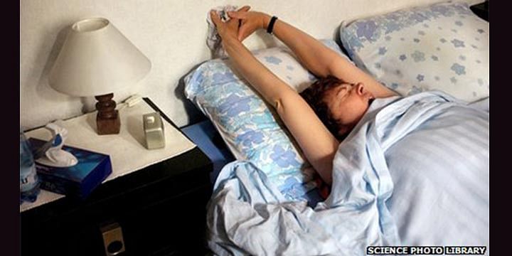 A woman in bed yawning. People are less likely to catch yawns the older they are, the study found. This photo is taken from BBC Online