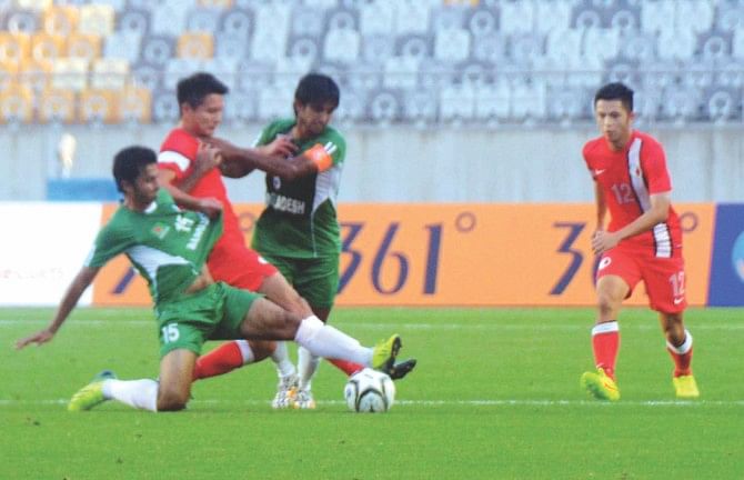 Bangladesh's Yeamin Munna (L) and Mamunul Islam (3rd from L) try to tackle a Hong Kong attacker during their Asian Games group match at the Hwaseong Stadium in Incheon on Monday. PHOTO: ANISUR RAHMAN