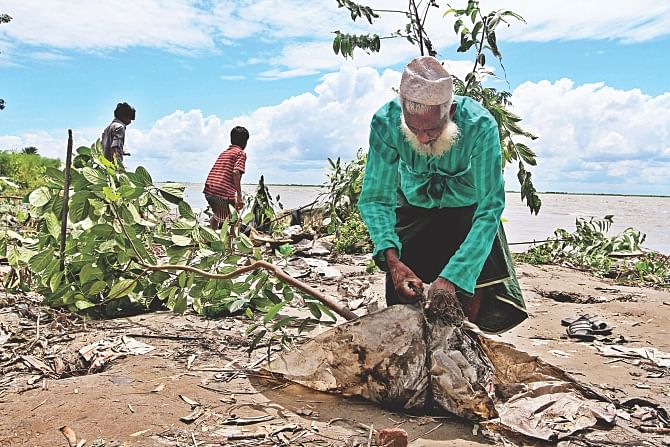This old man has lost almost everything in erosion. His house has been devoured by the Padma in Ranipur village in Dohar, Dhaka. A young jackfruit tree has somehow survived. He uprooted the tree to take it with him while moving to the next village. Photo: Anisur Rahman