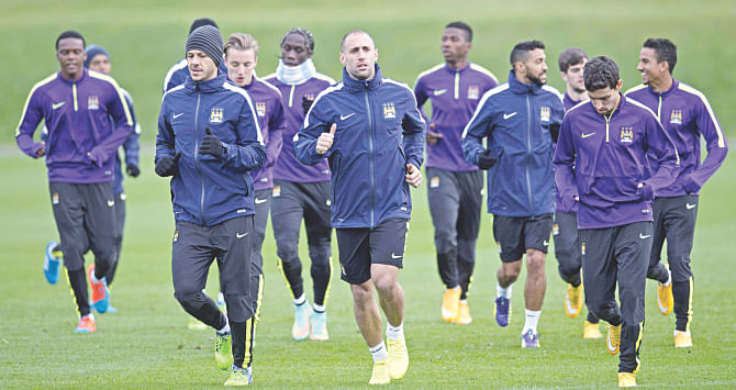 Manchester City defender Pablo Zabaleta (C) jogs with teammates prior to a training session at the City Football Academy yesterday ahead of their must win Champions League encounter against Bayern Munich. Photo: AFP