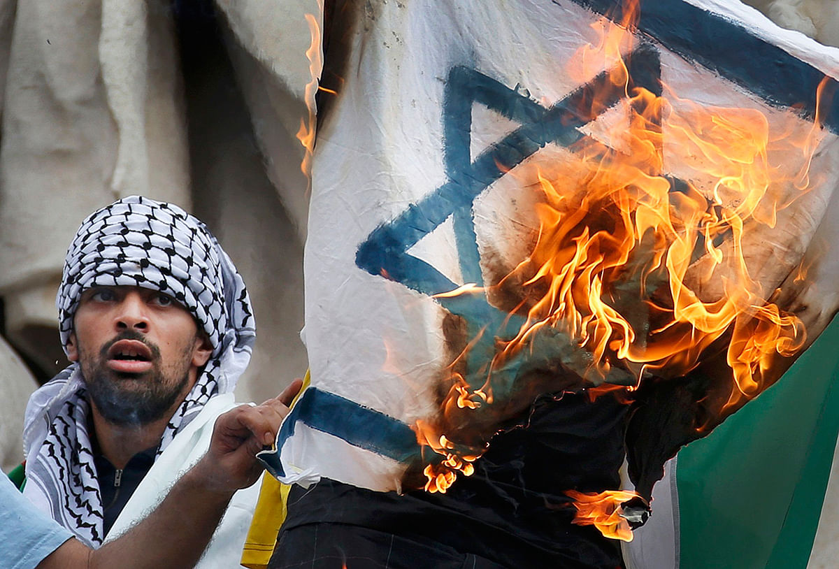 Pro Palestinian protester burns an Israeli flag during demonstration banned by police, in support of Gaza in central Paris, July 26, 2014. Photo: Reuters