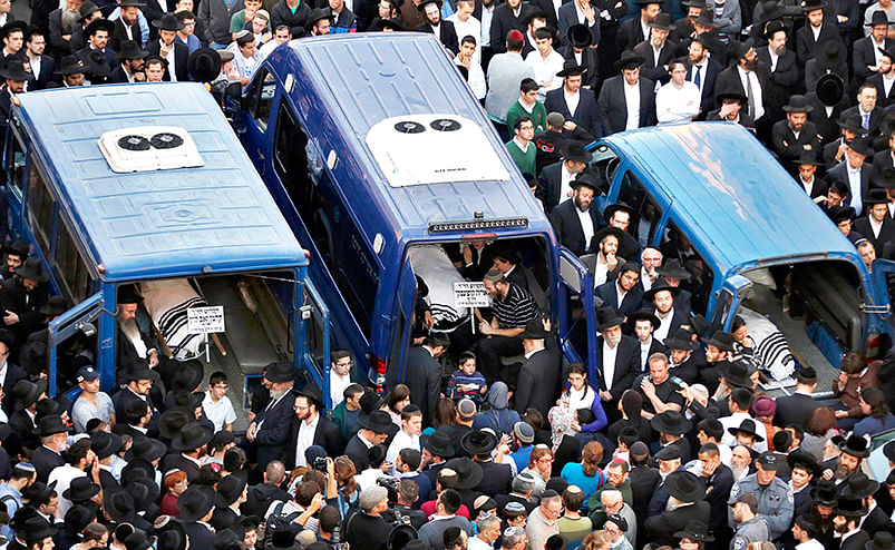 The bodies of Aryeh Kopinsky (C), Calman Levine (L) and Avraham Shmuel Goldberg lie in vehicles during their funeral near the scene of an attack at a Jerusalem synagogue, November 18, 2014. Photo: Reuters
