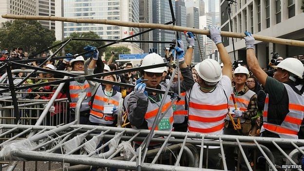 Workers in white hats started cutting into barricades as the clearance operation began. Photo: Reuters