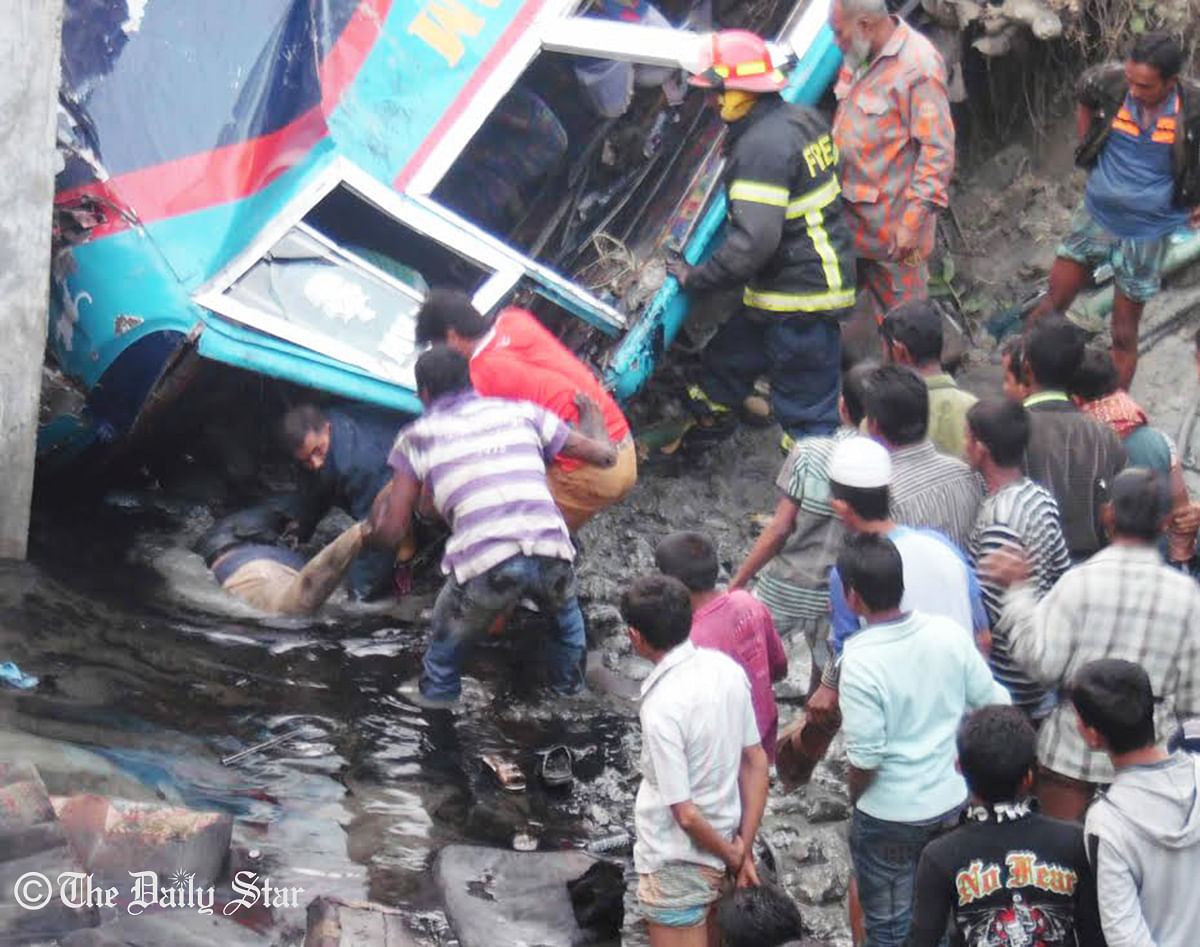 Local people rescue passengers from a bus that plunges into a ditch on Barisal-Jessore highway in Rajapur upazila of Jhalakathi, killing 10 people on Tuesday, December 23, 2014. Photo: Star