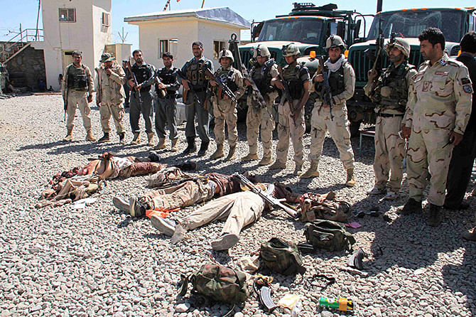 Afghan security forces gather around the bodies of dead Taliban insurgents at the site of a suicide attack in Ghazni Province September 4, 2014. Photo: Reuters