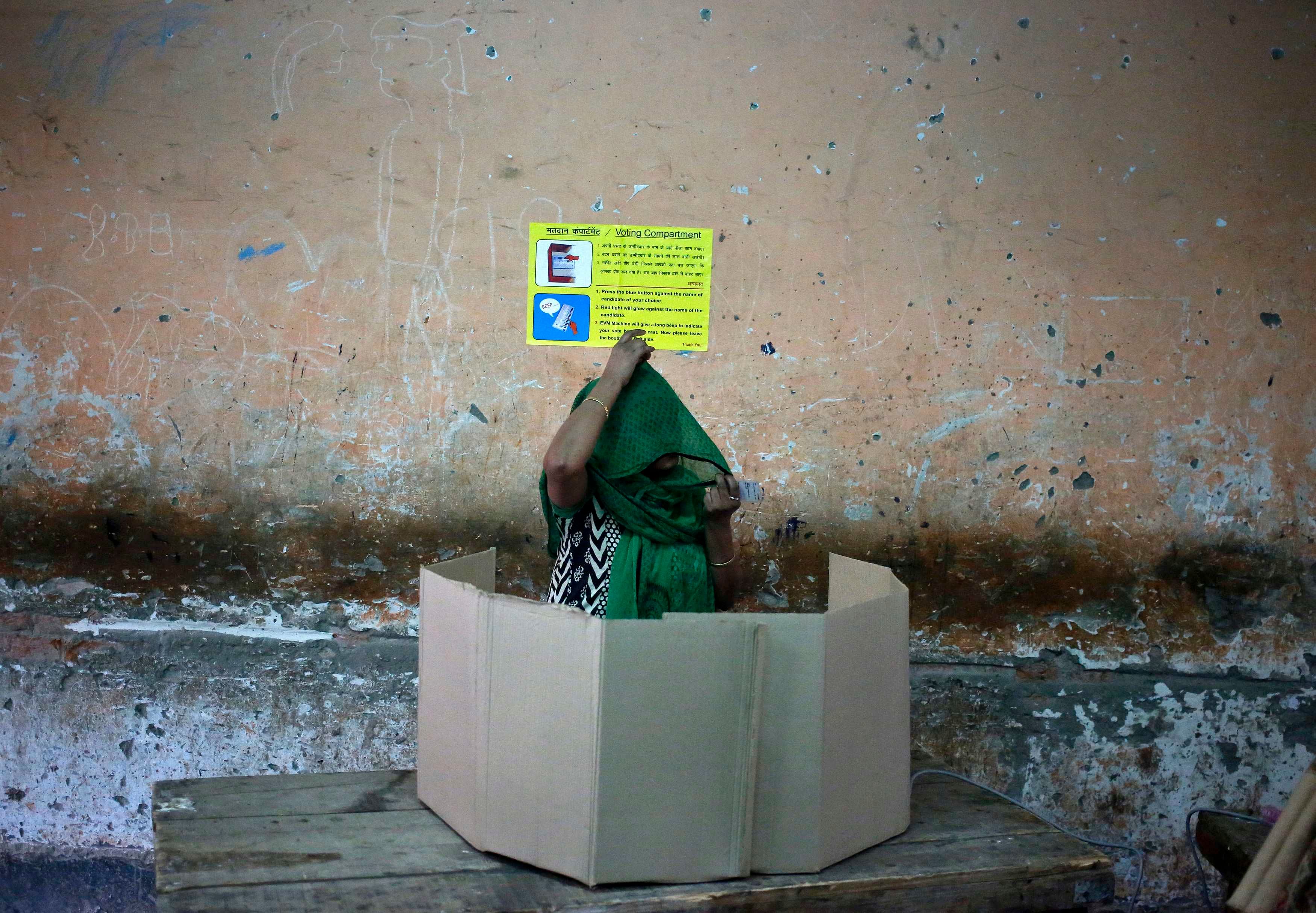 1.	A voter prepares to cast her vote at a polling station during the state assembly election in New Delhi February 7, 2015. Photo: Reuters