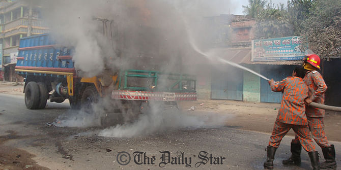 Fire fighters try to douse the blaze on a freight truck at Shibtola in Chapainawabganj on Thursday. Photo: Star