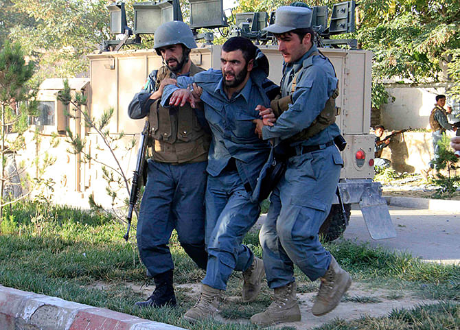 Afghan policemen help an injured comrade at the site of a suicide bomb attack in Ghazni Province September 4, 2014. Photo: Reuters