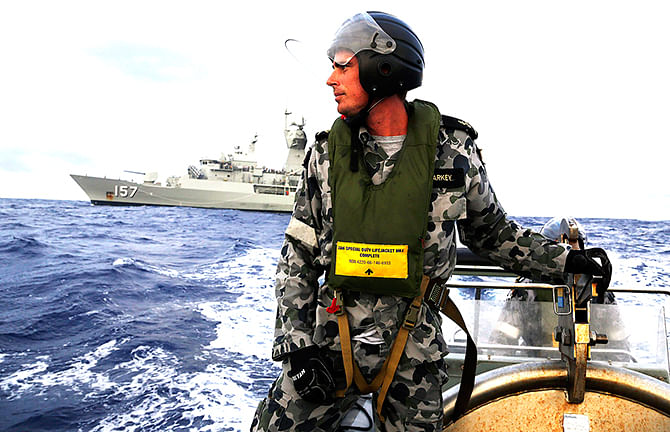Standing in a rigid hull inflatable boat launched from the Australian Navy ship searches for possible debris of MH370 in the southern Indian Ocean. Australian Defence Force released this on April 17. Photo: Reuters