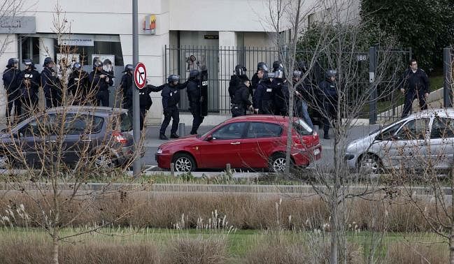 Members of the French police forces secure the area next to the post office in Colombes outside Paris, were an armed gunman is holding hostages January 16, 2015. Photo: Reuters