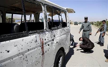 Afghan security personnel investigate a damaged vehicle after it was hit by a remote-controlled bomb on the outskirts of Kabul, Afghanistan, Tuesday. Photo: AP