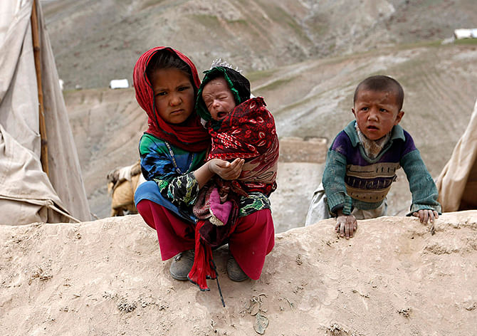 Displaced Afghan children sit outside their tent near the site of a landslide at the Argo district in Badakhshan province on Sunday. The United Nations put the death toll from Friday's massive landslide in Badakhshan province, bordering Tajikistan, at up to 500. Local officials say the number killed could be as high as 2,700.  Photo: Reuters